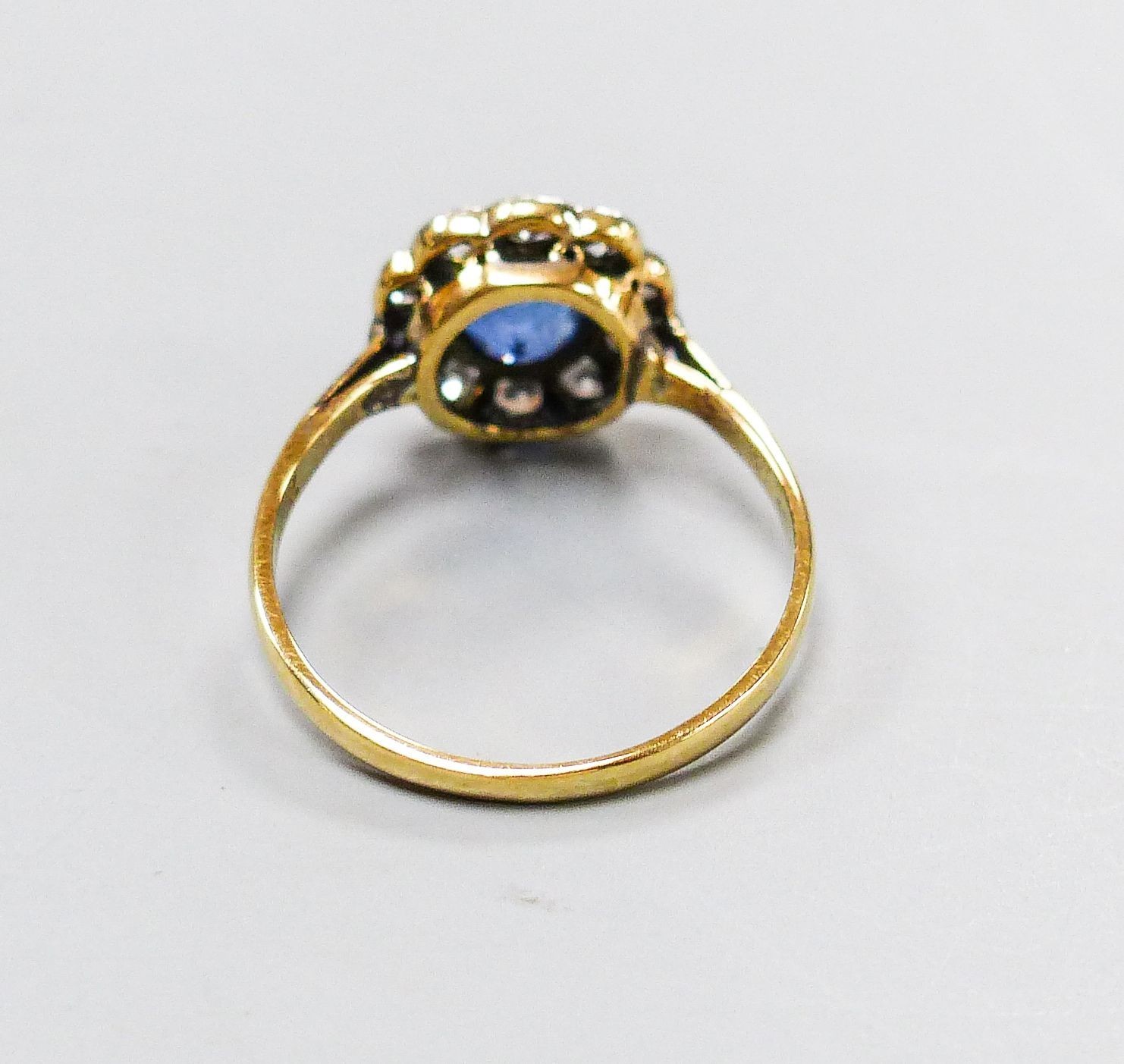 A yellow metal, sapphire and diamond cluster set flower head ring, size G, gross weight 1.6 grams.